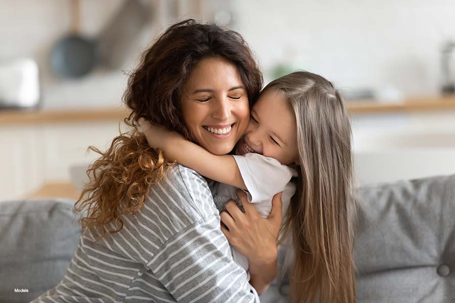 Mother and young daughter hugging
